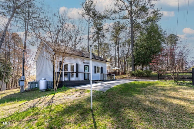 rear view of house with a wooden deck and a lawn