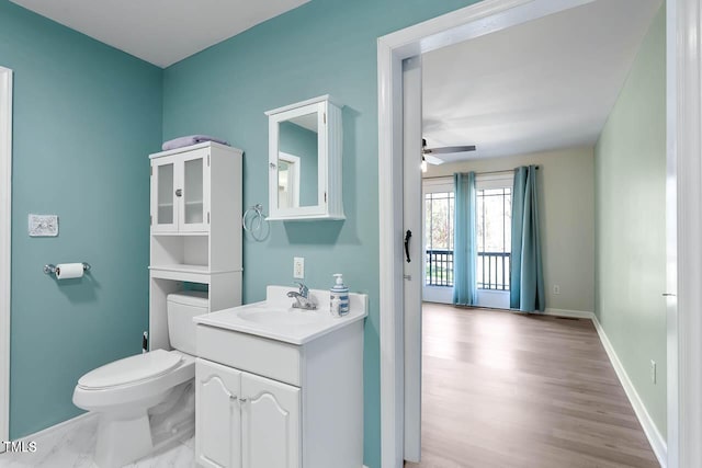 bathroom with ceiling fan, vanity, hardwood / wood-style flooring, and toilet