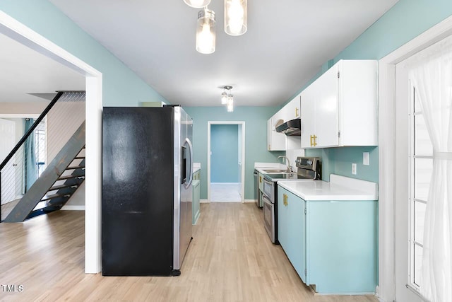 kitchen featuring sink, stainless steel appliances, pendant lighting, light hardwood / wood-style floors, and white cabinets