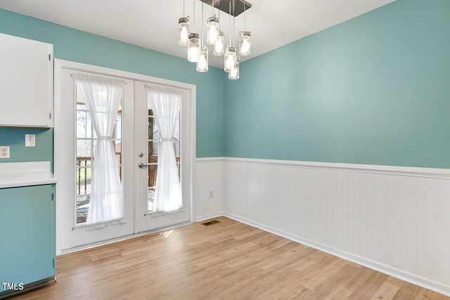 doorway featuring a chandelier, french doors, and light wood-type flooring