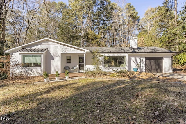 view of front of home with a front yard, a garage, and covered porch