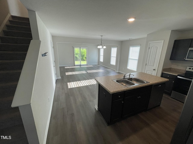 kitchen with a kitchen island with sink, dark wood-type flooring, an inviting chandelier, sink, and electric range oven