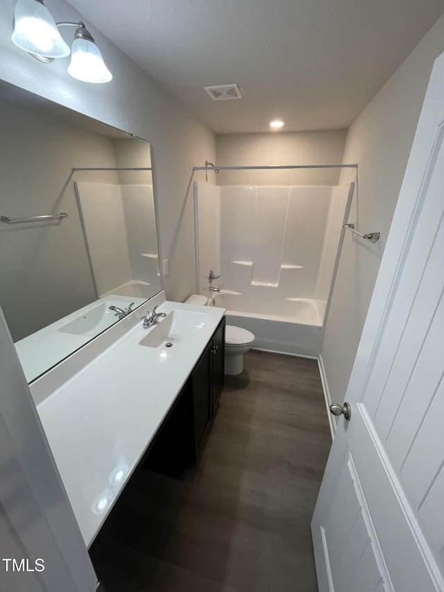 full bathroom with bathing tub / shower combination, hardwood / wood-style flooring, vanity, and toilet