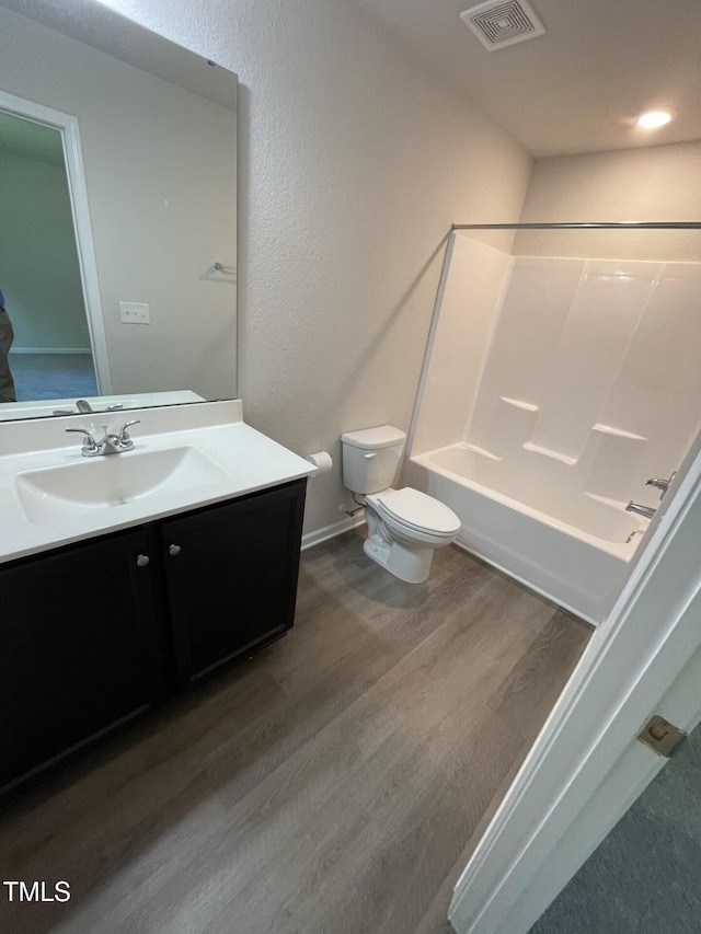 full bathroom with shower / tub combination, vanity, toilet, and hardwood / wood-style floors