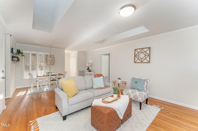 living room with ornamental molding and light hardwood / wood-style floors