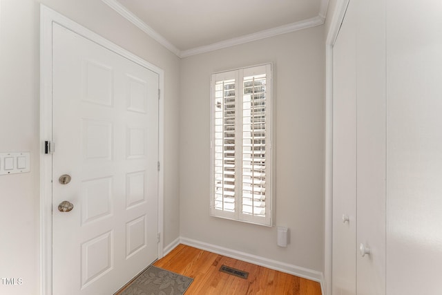 entrance foyer featuring ornamental molding and light wood-type flooring