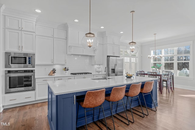 kitchen featuring a center island with sink, white cabinetry, and stainless steel appliances