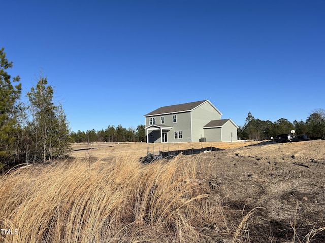 back of house with a rural view