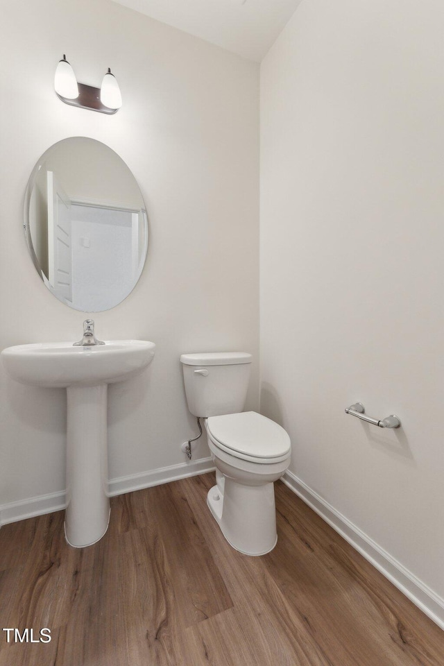 bathroom with wood-type flooring and toilet