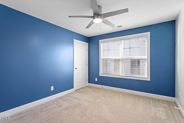 spare room featuring ceiling fan and light carpet