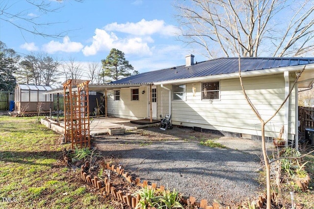 back of house with an outdoor structure and a patio area