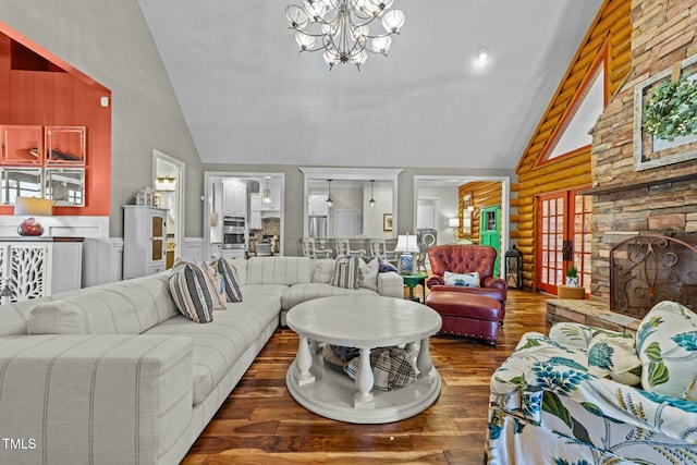 living room with a notable chandelier, dark hardwood / wood-style flooring, log walls, and vaulted ceiling