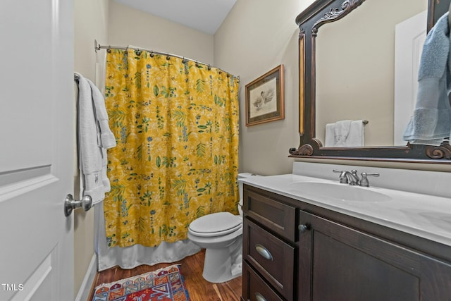 bathroom with toilet, vanity, hardwood / wood-style flooring, and walk in shower