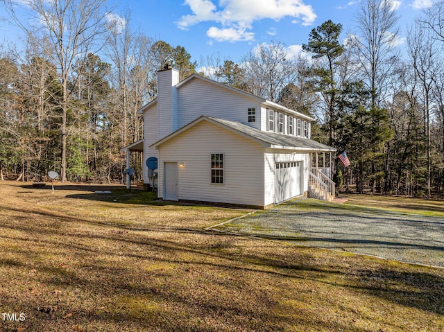 view of side of property featuring a garage and a lawn