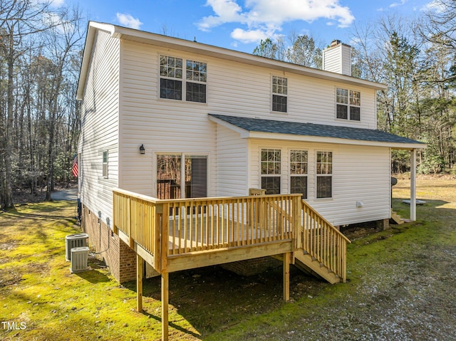 back of property featuring a deck, central AC unit, and a lawn