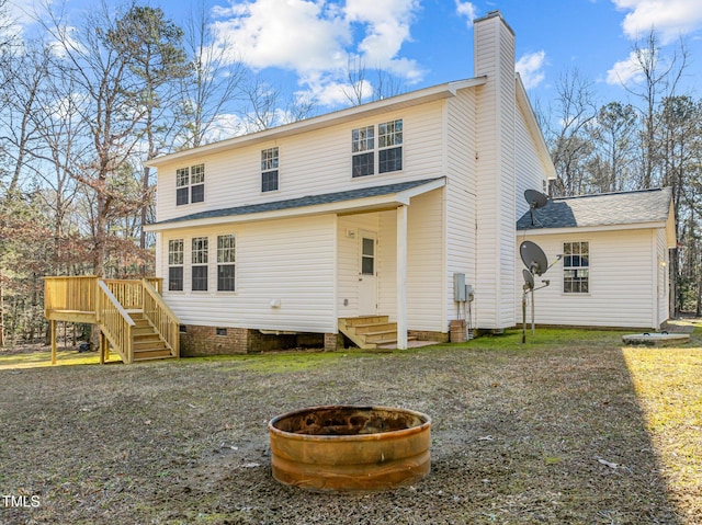 back of house with a deck and a fire pit