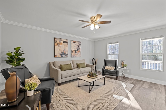 living room with ceiling fan, ornamental molding, and light hardwood / wood-style floors