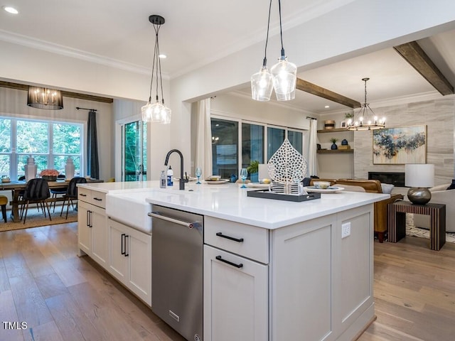 kitchen featuring light hardwood / wood-style floors, stainless steel dishwasher, white cabinets, and an island with sink