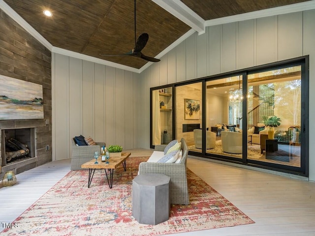 living room with vaulted ceiling with beams, a fireplace, and light hardwood / wood-style floors