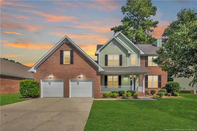 view of front of home with covered porch, a garage, and a lawn