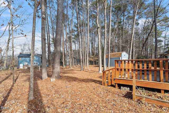 view of yard featuring a storage shed and a wooden deck