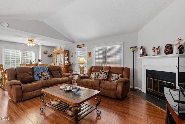 living room featuring wood-type flooring, vaulted ceiling, and ceiling fan