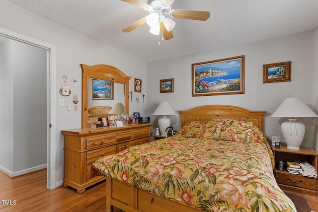 bedroom featuring a textured ceiling, light hardwood / wood-style floors, and ceiling fan