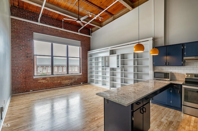 kitchen with blue cabinetry, appliances with stainless steel finishes, beamed ceiling, wood ceiling, and brick wall