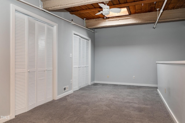 unfurnished bedroom with carpet flooring, multiple closets, and wood ceiling