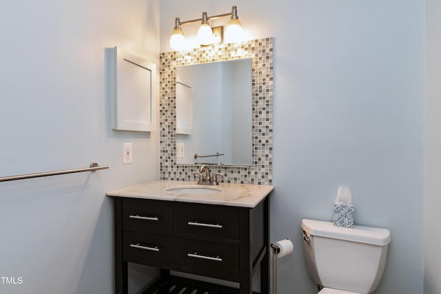 bathroom with backsplash, vanity, and toilet