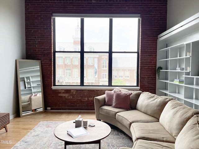 living room with brick wall and light hardwood / wood-style floors