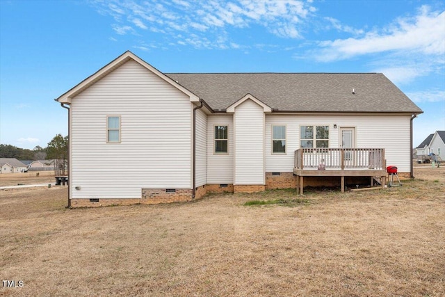 back of property featuring a deck and a lawn