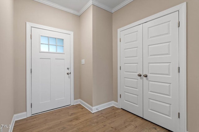 entrance foyer with ornamental molding and light hardwood / wood-style floors