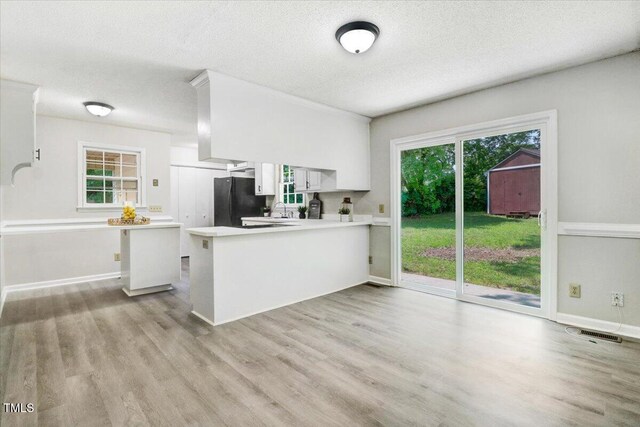 103 Val Del Ct, Garner, NC 27529 - kitchen featuring light countertops, freestanding refrigerator, a sink, a peninsula, and white cabinetry