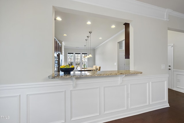 kitchen featuring pendant lighting, ornamental molding, dark hardwood / wood-style flooring, and light stone counters