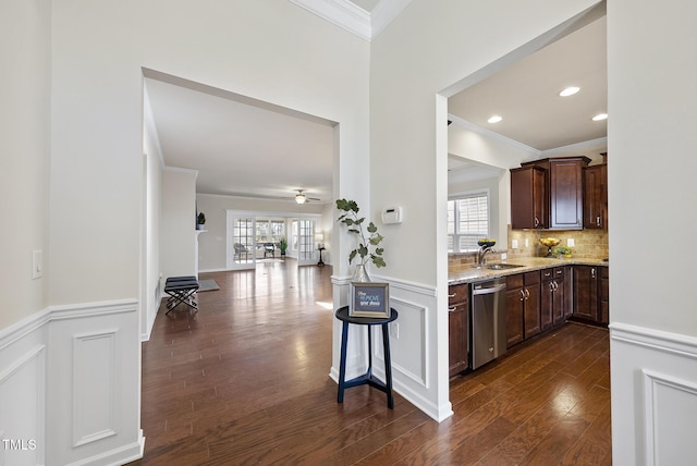 kitchen with light stone counters, dark brown cabinets, plenty of natural light, dark hardwood / wood-style floors, and dishwasher