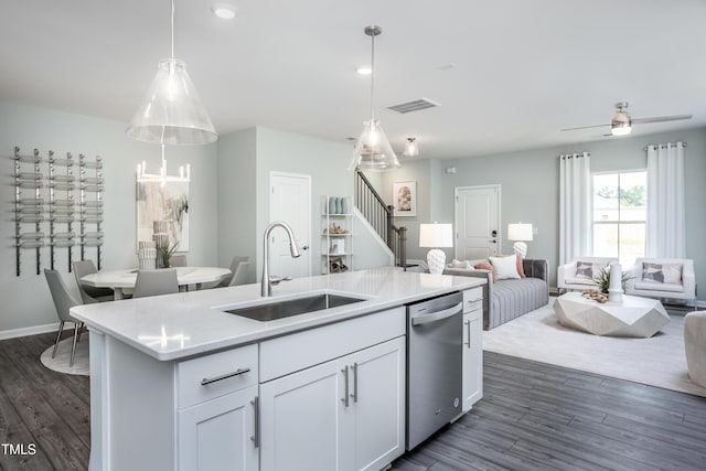 kitchen with stainless steel dishwasher, sink, decorative light fixtures, a center island with sink, and white cabinets