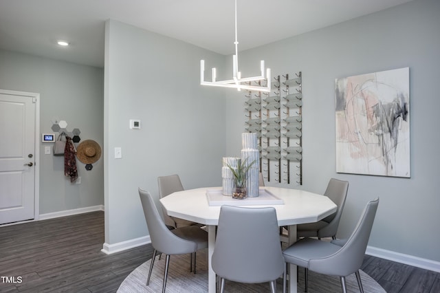 dining space with dark hardwood / wood-style floors and an inviting chandelier