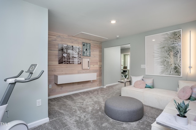 living room with carpet and wood walls