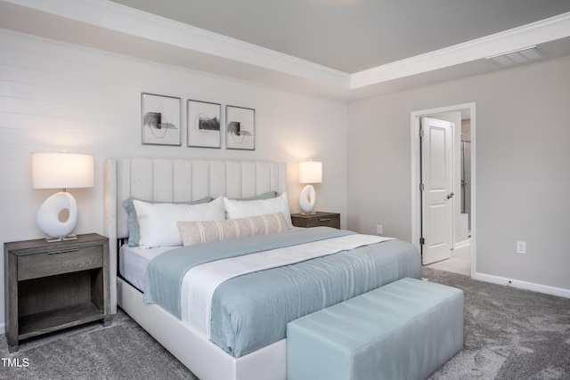 carpeted bedroom with ensuite bath and ornamental molding