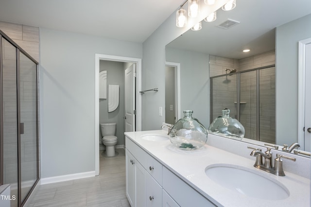 bathroom featuring toilet, an enclosed shower, and vanity