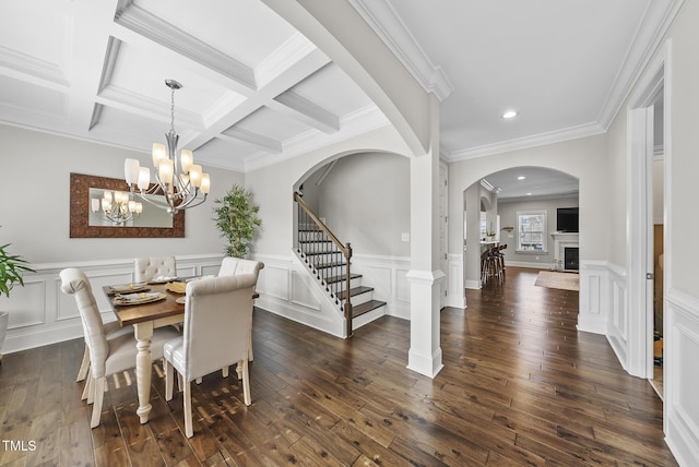 dining room featuring dark hardwood / wood-style floors, crown molding, coffered ceiling, and beamed ceiling