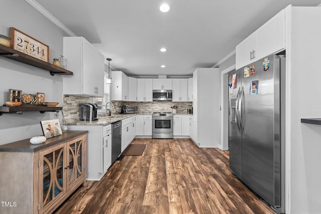 kitchen featuring dark wood-type flooring, decorative light fixtures, stainless steel appliances, white cabinets, and sink