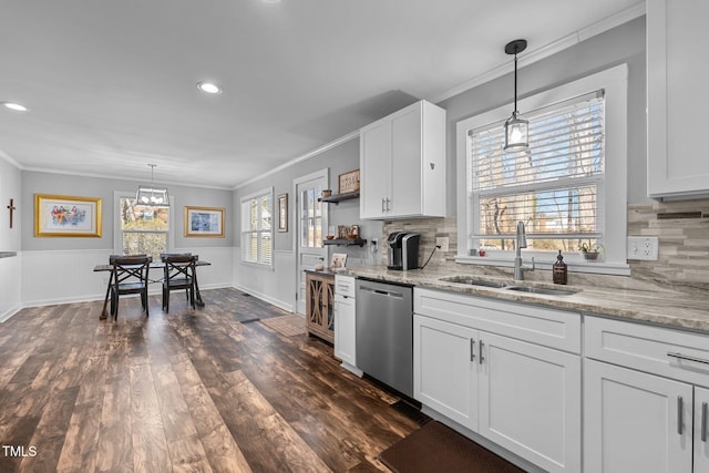 kitchen with white cabinets, stainless steel dishwasher, hanging light fixtures, and sink