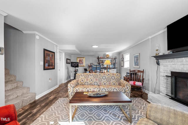 living room featuring a fireplace, hardwood / wood-style floors, and crown molding