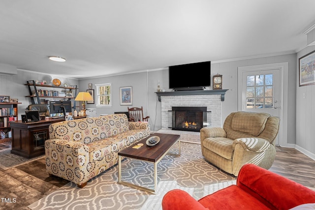 living room featuring dark hardwood / wood-style flooring, a fireplace, plenty of natural light, and crown molding