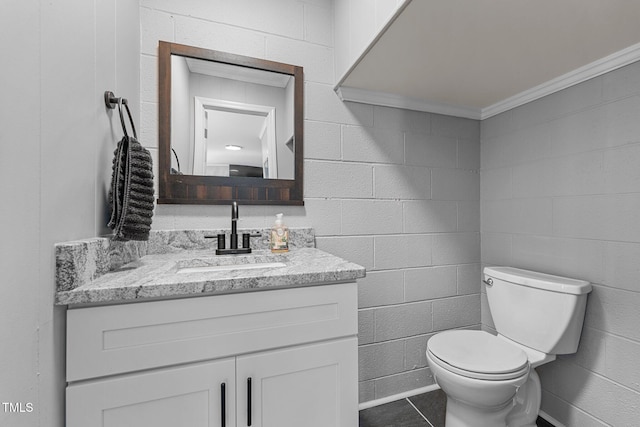 bathroom featuring toilet, tile patterned floors, crown molding, and vanity