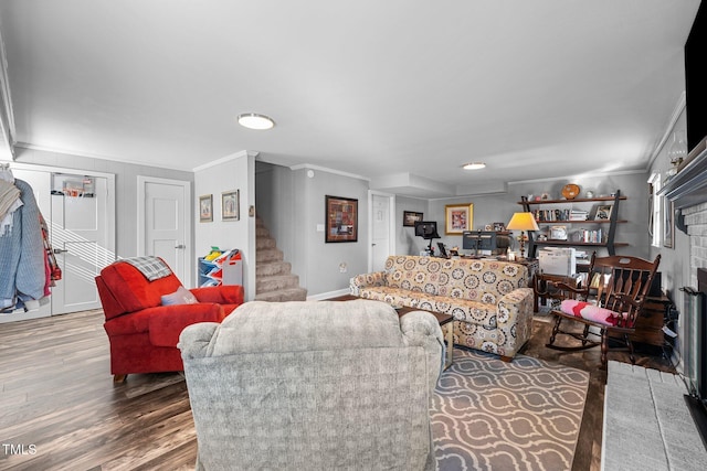 living room featuring a fireplace, dark wood-type flooring, and crown molding