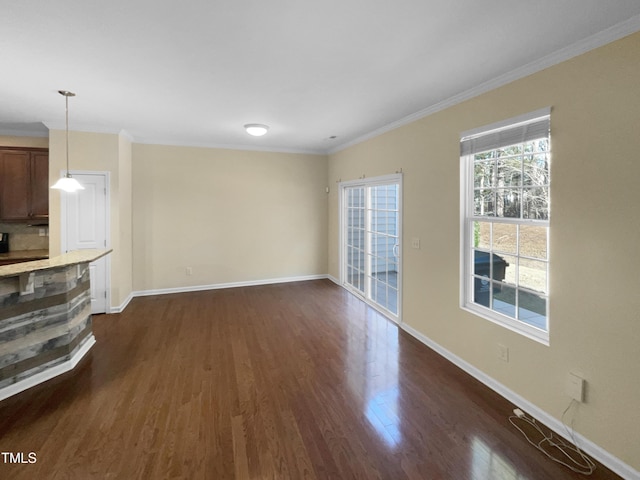 unfurnished living room featuring dark hardwood / wood-style flooring and ornamental molding