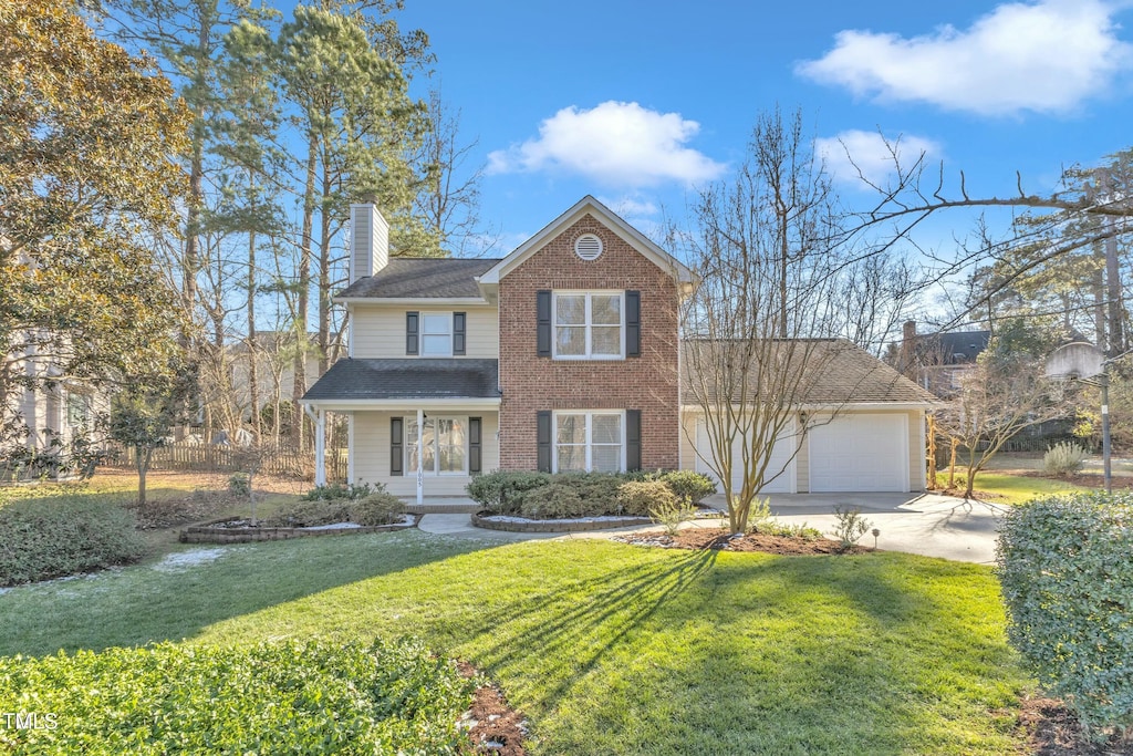 view of front facade featuring a front yard, a garage, and covered porch